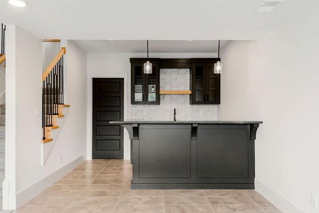 Bar with stairway, light tile patterned floors, decorative backsplash, baseboards, and decorative light fixtures | Image 32