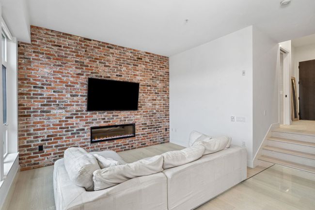 Living room featuring a glass covered fireplace, baseboards, and wood finished floors | Image 4