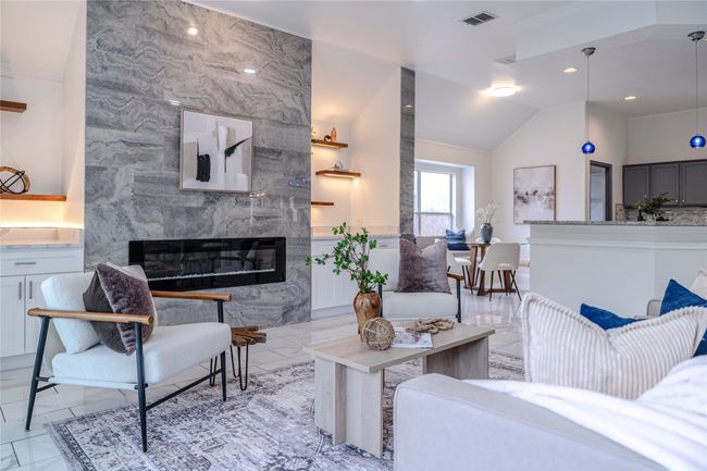 Living room with a high end fireplace, lofted ceiling, light marble finish floors, and ornamental molding | Image 19