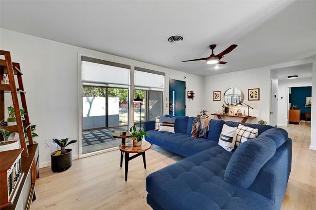 Floor-to-ceiling windows allow an abundance of natural light to pour in and brings a lovely glow to the living room. | Image 9