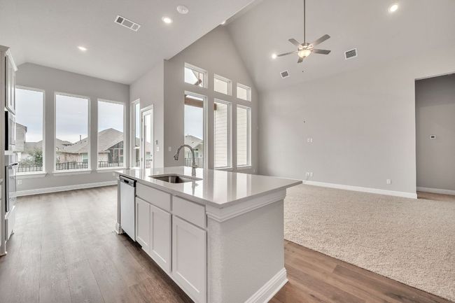 Kitchen with white cabinets, a kitchen island with sink, open floor plan, and a sink | Image 6