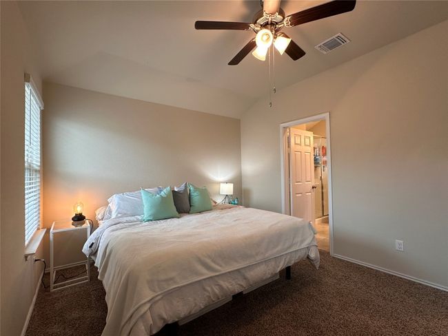 Carpeted bedroom featuring multiple windows, baseboards, lofted ceiling, and a ceiling fan | Image 30