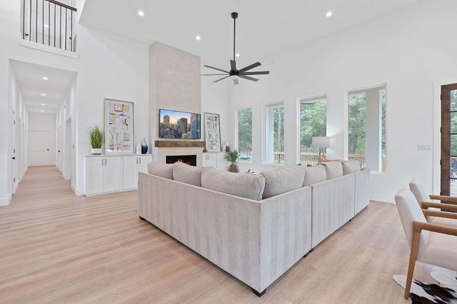 Living room with light wood-style floors, a large fireplace, and recessed lighting | Image 8