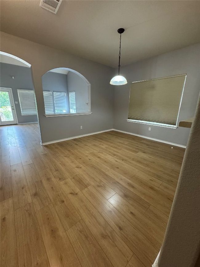 Spare room featuring hardwood / wood-style flooring, arched walkways, and baseboards | Image 8