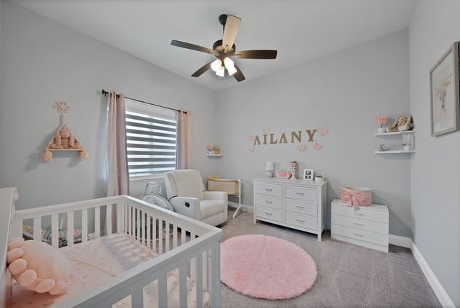 Bedroom featuring a crib, carpet floors, baseboards, and a ceiling fan | Image 18