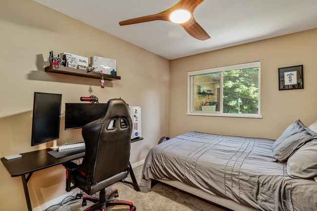 Carpeted bedroom with a desk and ceiling fan | Image 19