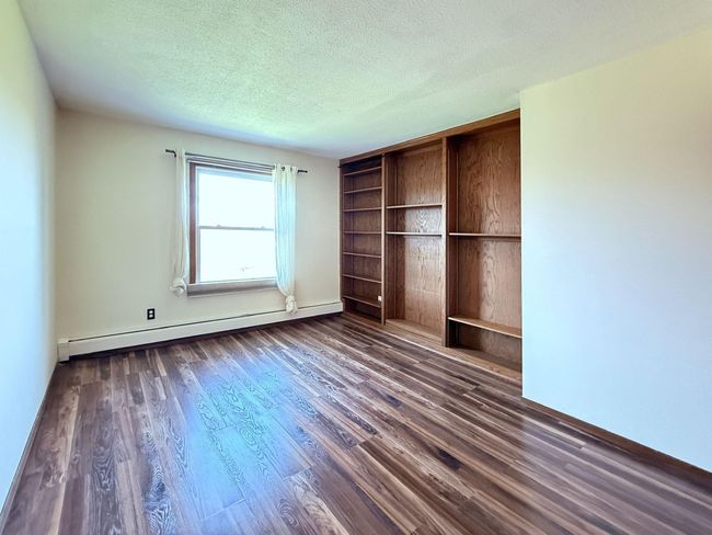The second bedroom has built in shelves and space for a desk | Image 14