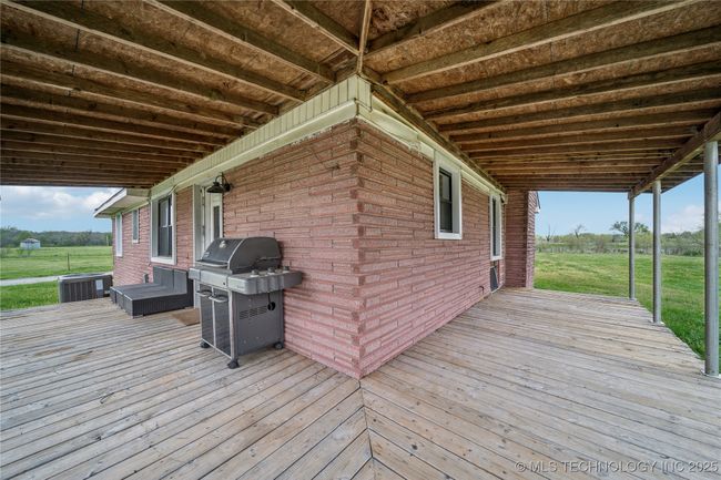 Deck featuring central air condition unit, grilling area, and a yard | Image 27
