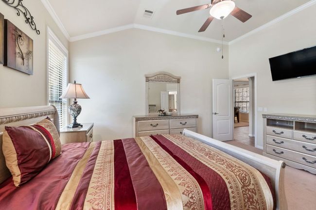 Bedroom with crown molding, lofted ceiling, carpet, and ceiling fan | Image 25