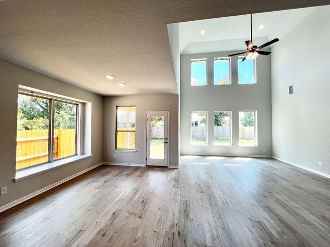 Unfurnished living room featuring light wood-type flooring, a ceiling fan, and recessed lighting | Image 11
