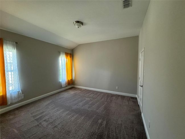 Empty room with dark colored carpet and lofted ceiling | Image 34