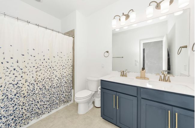 Bathroom with tile patterned flooring, a sink, double vanity, and toilet | Image 23