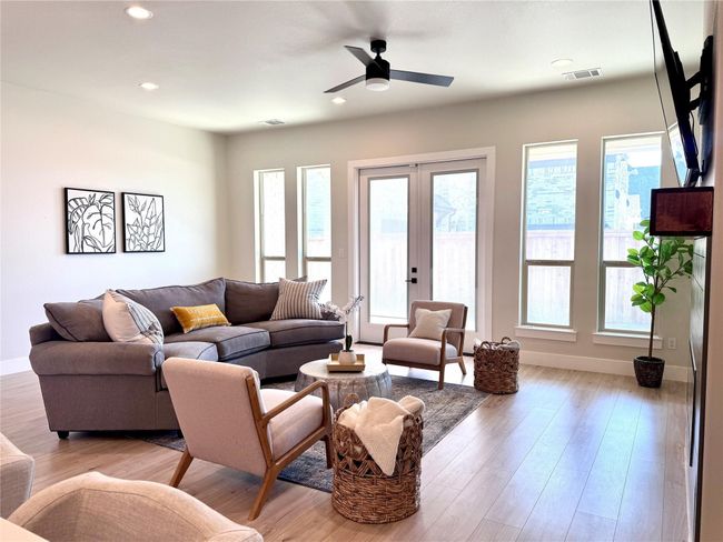Living area with healthy amount of natural light, ceiling fan, light wood-style floors, and recessed lighting | Image 14