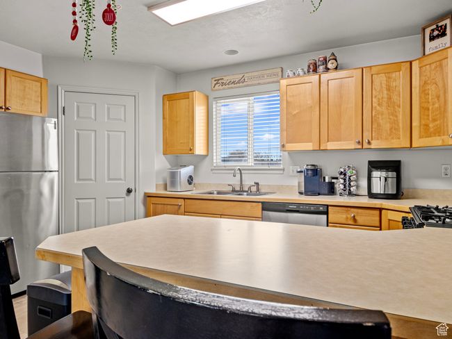Kitchen featuring light brown cabinets, sink, and stainless steel appliances | Image 13