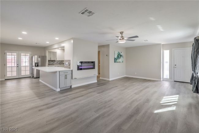 Unfurnished living room with recessed lighting, visible vents, baseboards, light wood-style floors, and french doors | Image 9