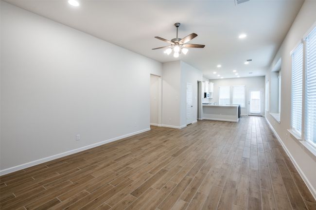 Unfurnished living room with ceiling fan and wood-type flooring | Image 9