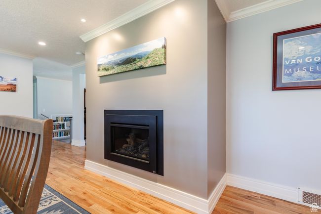 Hallway with wood finished floors, baseboards, ornamental molding, visible vents, and recessed lighting | Image 9