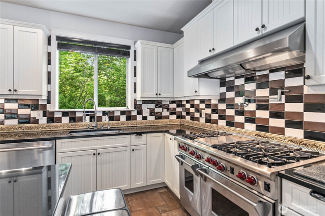 The kitchen is a chef's dream, complete with Wolf 6-burner range, grill, and double-oven. Also has a built-in pot filler. | Image 4