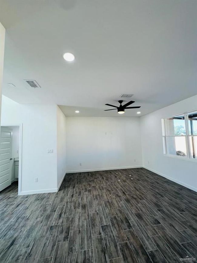 Spare room with dark wood-type flooring and ceiling fan | Image 9