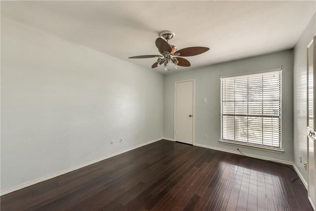 Empty room with dark wood-style flooring and a ceiling fan | Image 10