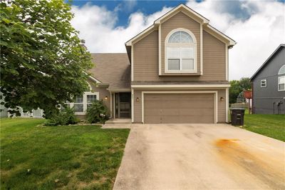 View of front of property with a front yard and a garage | Image 1