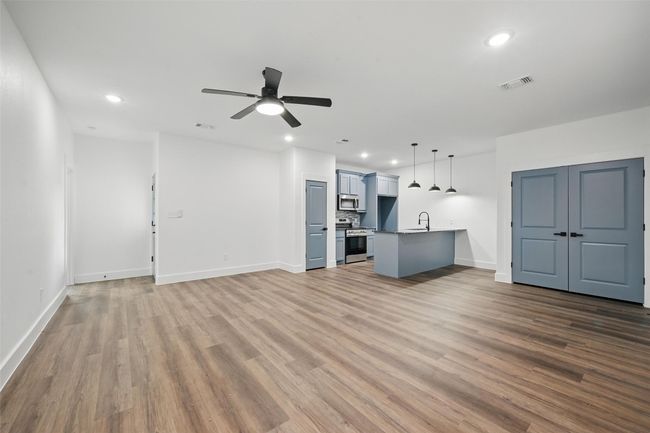 Unfurnished living room featuring recessed lighting, visible vents, ceiling fan, a sink, and wood finished floors | Image 5