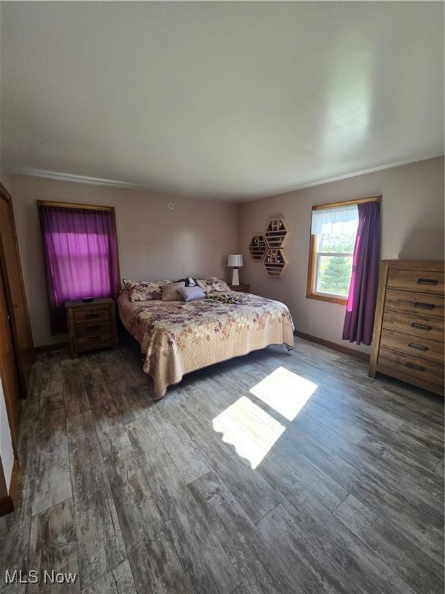 Bedroom featuring baseboards and wood finished floors | Image 8