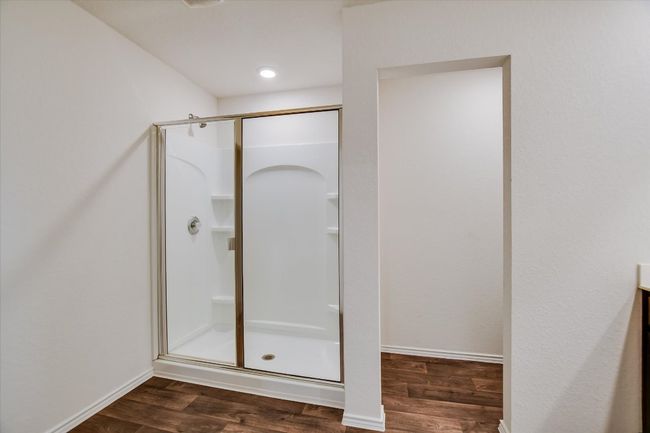 Bathroom with baseboards, a shower stall, and wood finished floors | Image 13