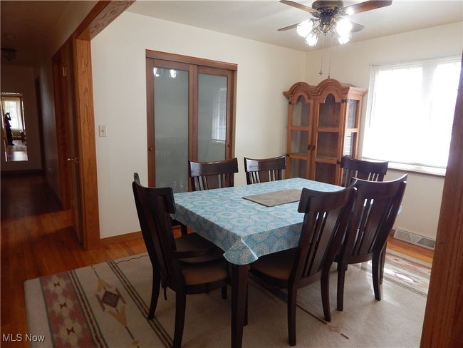 Formal Dining room features ceiling fan, hard wood-style flooring, and double sized, glass door Pantry. | Image 13