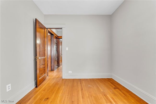 Spare room featuring baseboards and light wood-type flooring | Image 18