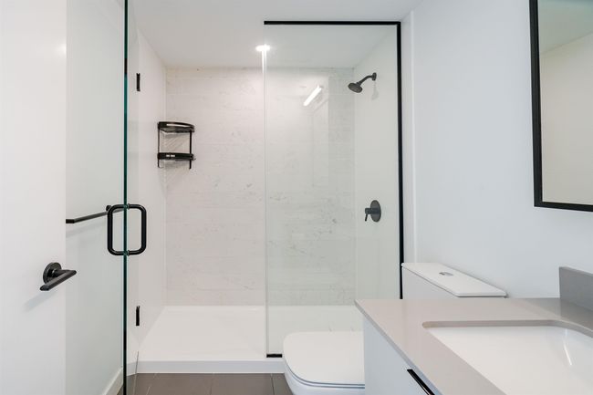 Full bathroom featuring toilet, a stall shower, vanity, and tile patterned flooring | Image 25