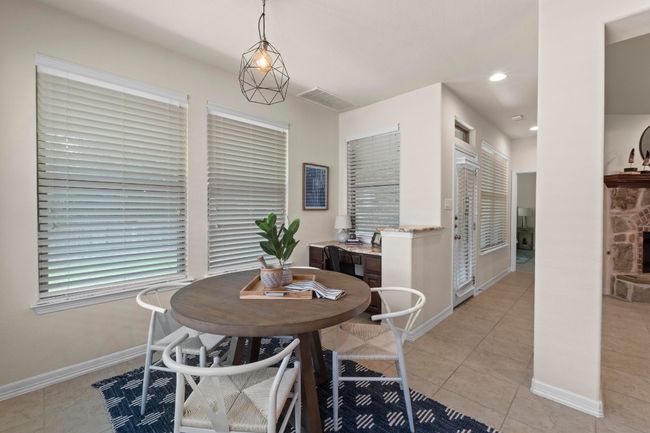 Dining space with light tile patterned flooring, a fireplace, and recessed lighting | Image 14