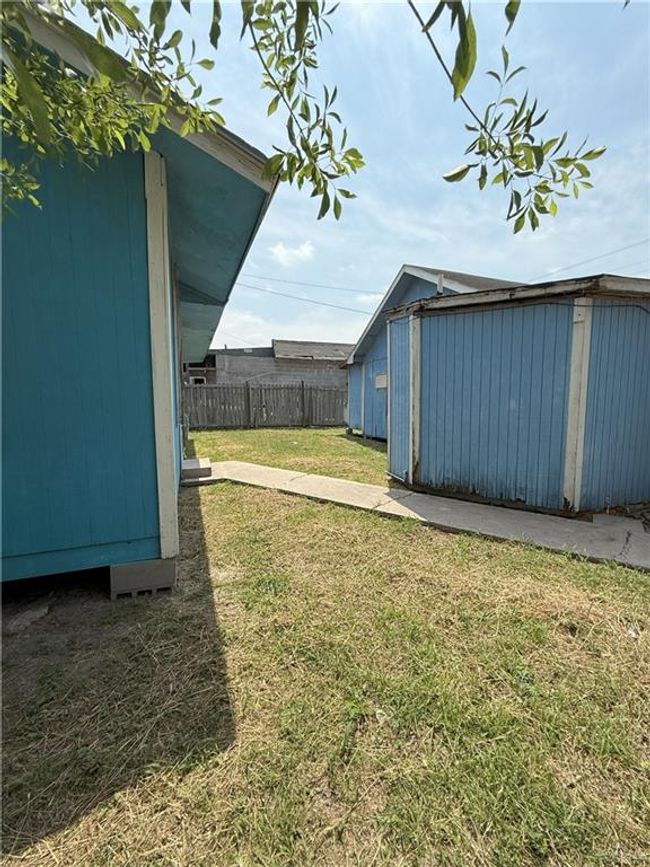 View of yard with a storage shed, fence, and an outbuilding | Image 31