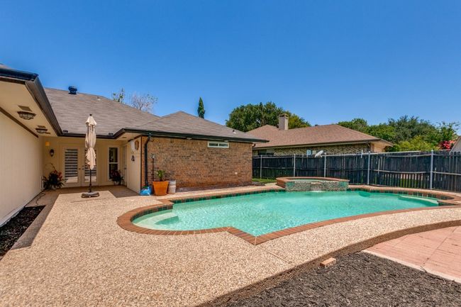 View of swimming pool featuring a patio area, a fenced backyard, french doors, and a pool with connected hot tub | Image 23