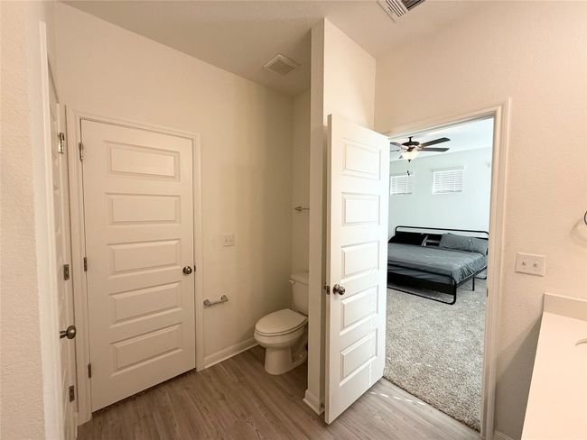 Ensuite bathroom with toilet, wood finished floors, and a ceiling fan | Image 17