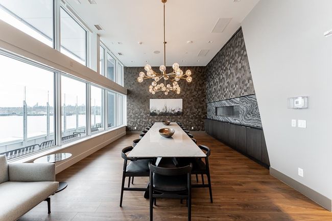 Dining room with an accent wall, a towering ceiling, visible vents, a chandelier, and wood finished floors | Image 25