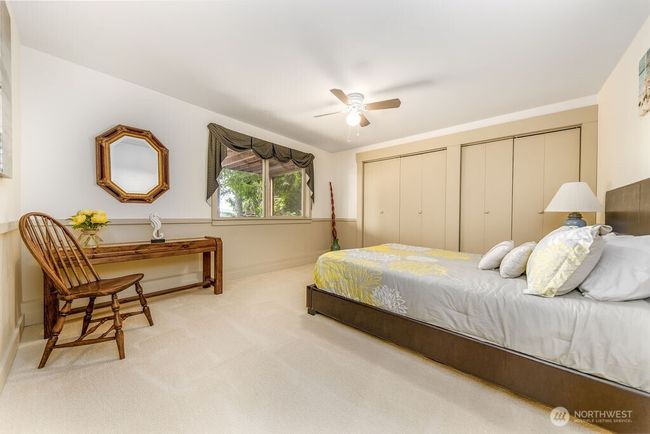 Ground level bedroom looks out to garden and firepit area. | Image 20