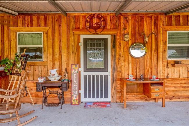 The wood-sided façade exudes warmth, with a charming front door anchoring the home’s rustic character, offering an inviting first impression that sets the tone for what’s inside. | Image 5