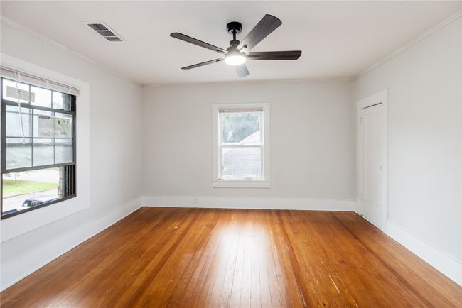Unfurnished room with hardwood / wood-style floors, plenty of natural light, ceiling fan, baseboards, and crown molding | Image 18
