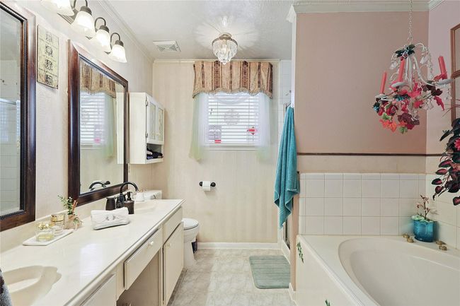 Primary bathroom featuring double sinks, a sitting vanity, separate shower, and soaking tub — a private retreat offering both comfort and luxury. | Image 15