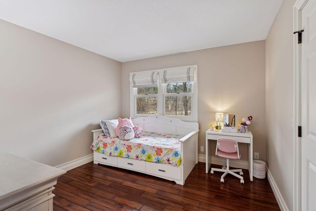 Main floor bedroom faces front yard and has fresh paint and hardwood floors. | Image 23