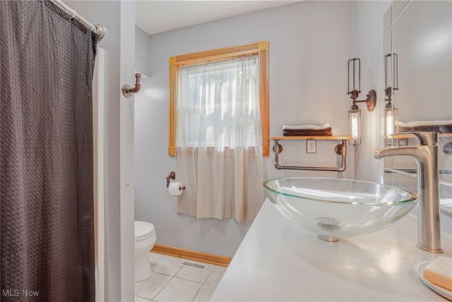 Bathroom featuring tile patterned floors, curtained shower, and vanity | Image 23