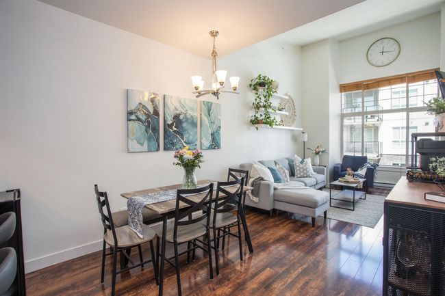 Dining room featuring baseboards, wood finished floors, a chandelier, and a baseboard radiator | Image 6