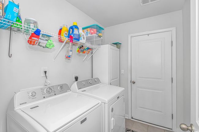 Laundry room with washing machine and dryer and light tile patterned floors | Image 18