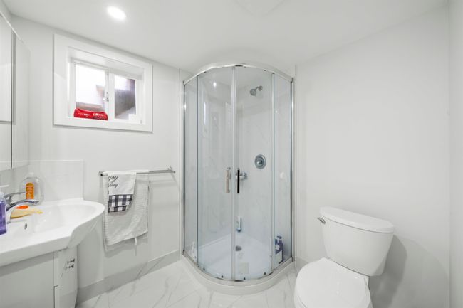 Bathroom featuring toilet, vanity, a marble finish shower, marble finish floor, and recessed lighting | Image 22