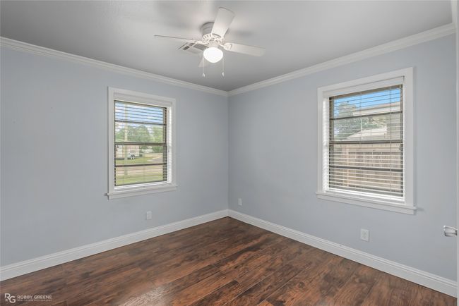 Empty room featuring ornamental molding, dark wood finished floors, and baseboards | Image 18