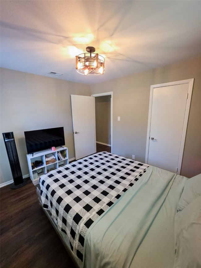 Bedroom featuring dark wood-style flooring and baseboards | Image 8
