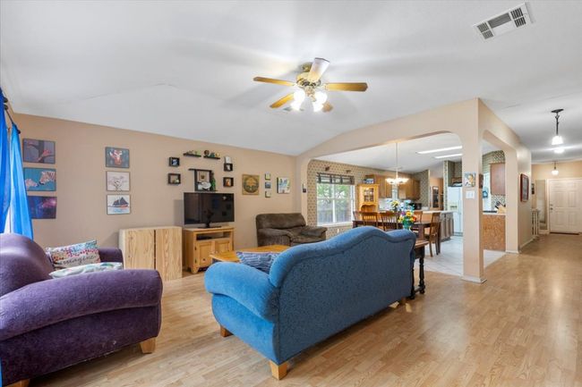 Living room featuring light wood finished floors, ceiling fan, vaulted ceiling, and arched walkways | Image 18
