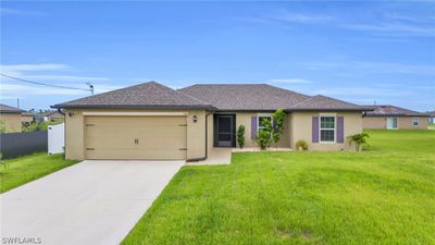 Ranch-style home featuring a garage and a front yard | Image 2