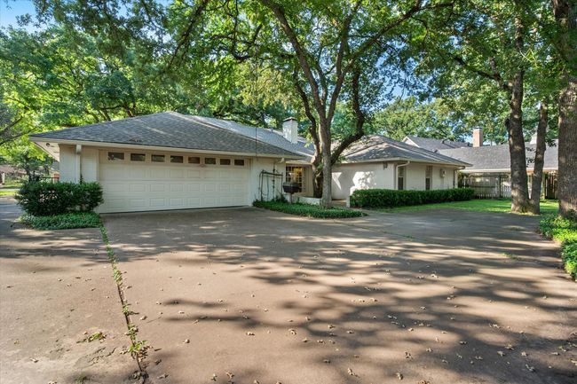 Single story home featuring concrete driveway, an attached garage, and a chimney | Image 40